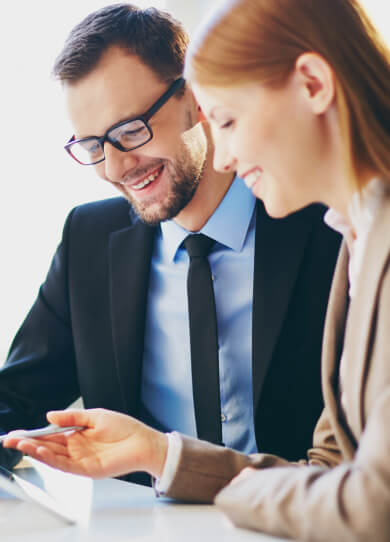 Dos compañeros de trabajo revisando unos documentos en el celular